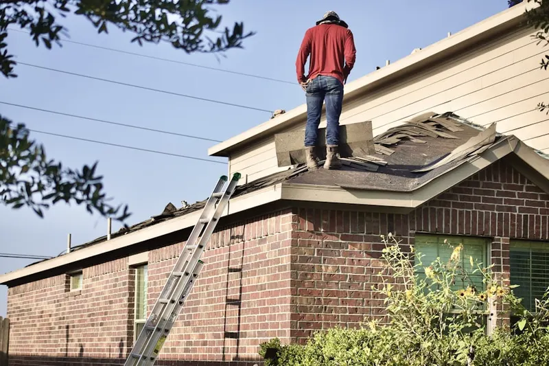 Professional roofer working on a residential roof in Alvin